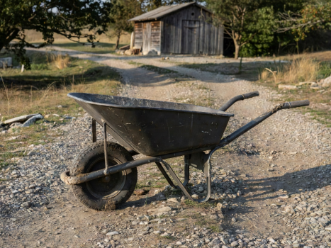 A heavy duty wheelbarrow parked on a gravel path